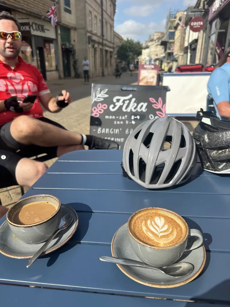 Bike helmet and coffee on a table outside Fika Stamford