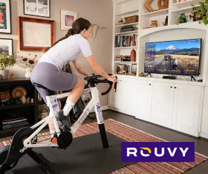 lady in living room taking indoor rouvy bike ride on zwift v2 and kickr core 2